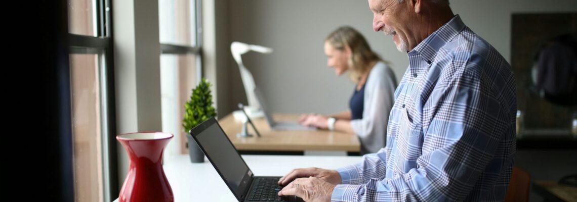 harvest wisdom - older man sitting at a desk with a computer