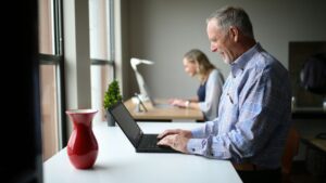 harvest wisdom - older man sitting at a desk with a computer