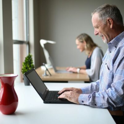 harvest wisdom - older man sitting at a desk with a computer